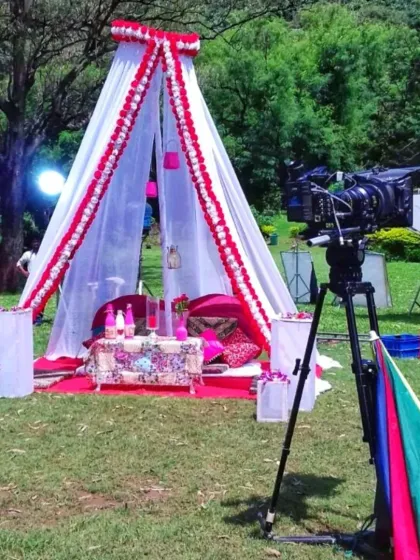 A behind-the-scenes shot of a video shoot in a park, featuring a decorative teepee tent I created for the set.