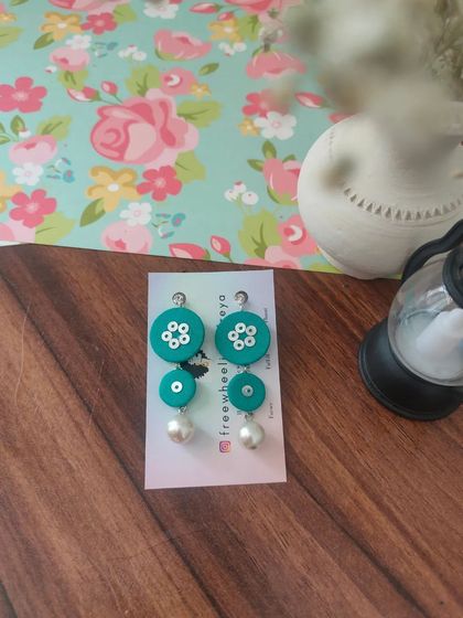 These tiered fabric earrings with pearl drops are a modern and chic design. They are available in pink, black, and teal, and are incredibly lightweight and comfortable.