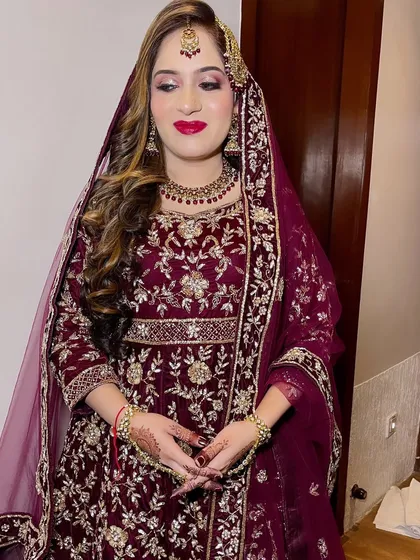 A beautiful bride in a deep wine-colored velvet outfit. The classic red lip and soft curls complete this elegant and royal look.