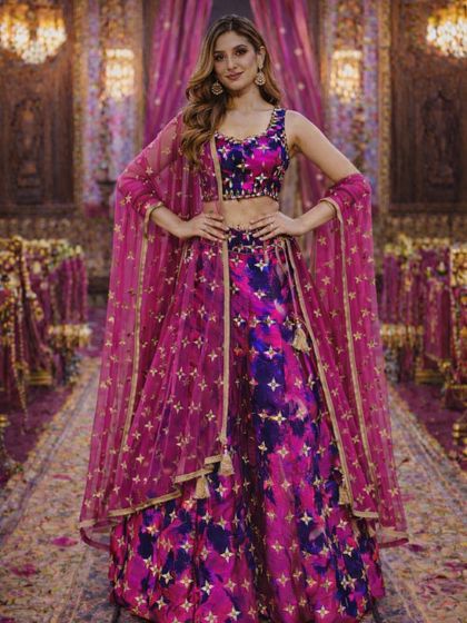 This pose shows the full spread of the dupatta, which adds another layer of elegance to this already stunning pink and purple lehenga.