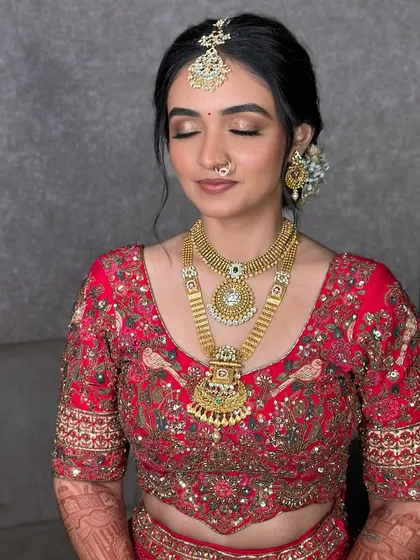 With eyes closed, you can see the delicate eyeshadow work. The look is designed to be ethereal and timeless, complementing her heavy gold jewelry.