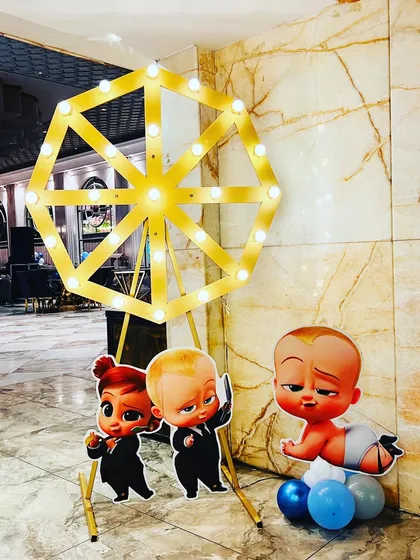 Fun props for a Boss Baby themed party, including character standees and a light-up ferris wheel.