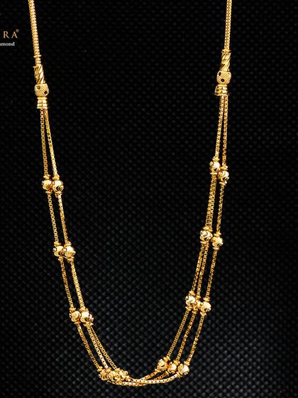 A beautiful multi-layered gold chain necklace, crafted using techniques that ensure a delicate and lightweight feel. The dangling beads add a touch of movement and grace.
