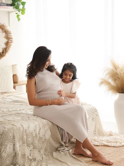 A quiet moment between a mother and her daughter, sharing the anticipation of the new arrival. The soft lighting and boho decor create a warm and gentle atmosphere.