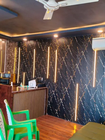 A wider view of the terrace room's interior, showing the kitchenette, air conditioning, and the unique textured wall with custom lighting.