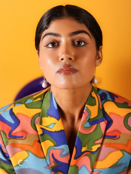 An intense and captivating close-up. Her direct gaze is powerful, and the glossy lips add a touch of glamour to the artistic look.