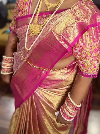 A close-up of the saree draping, focusing on the neat pleats and the way the fabric falls elegantly over the shoulder.