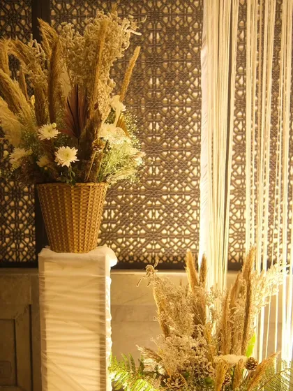 Another detail shot of our pampas grass arrangements. Placed on white pedestals against a decorative screen, these pieces add texture and height to the overall event design.