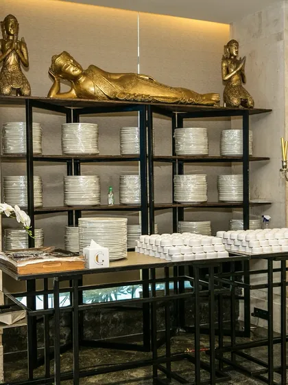 An example of our themed decor, featuring golden Buddha statues and neatly stacked plates. This setup adds a touch of serenity and cultural elegance to the dining environment.