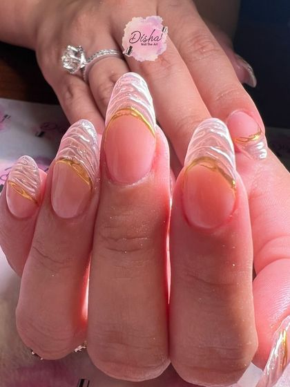 A sophisticated and elegant design. These nails feature a sheer base with textured, pearlescent tips outlined in a beautiful liquid gold effect.