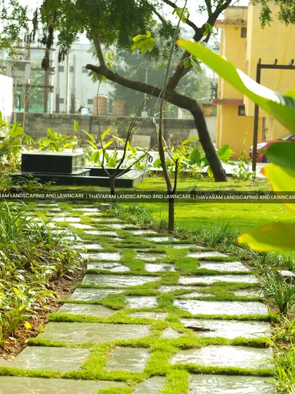 A winding path of stone pavers and grass leads through this lush garden, inviting a leisurely stroll.