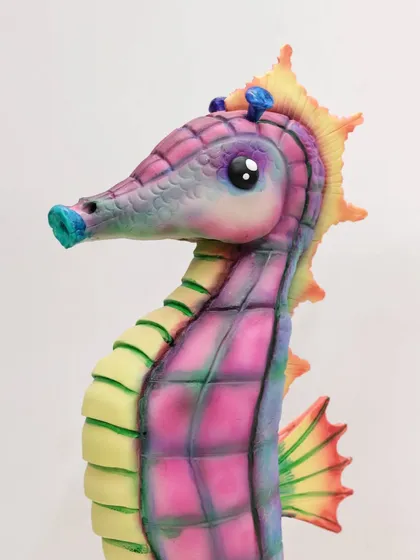 A close-up of the seahorse cake's head, showing the delicate airbrushed color transitions and hand-sculpted details.