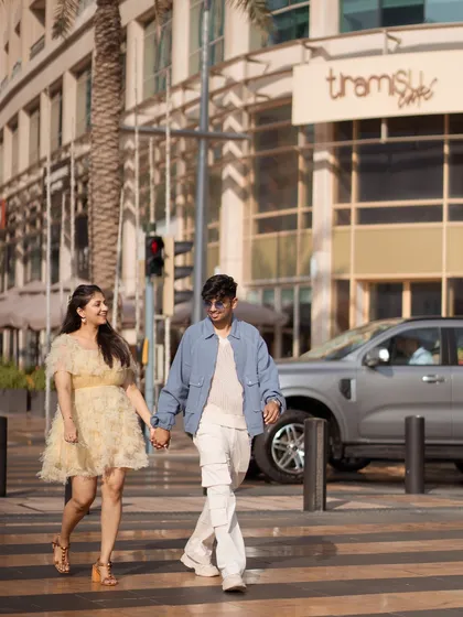 A candid shot of the couple walking hand-in-hand across a Dubai street. This captures the natural, everyday moments of love, even in an extraordinary destination.