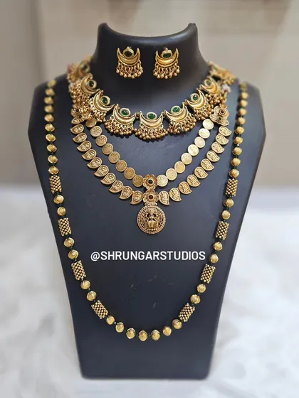 A traditional layered set featuring a unique crescent necklace, a coin haar, and a long beaded mala.