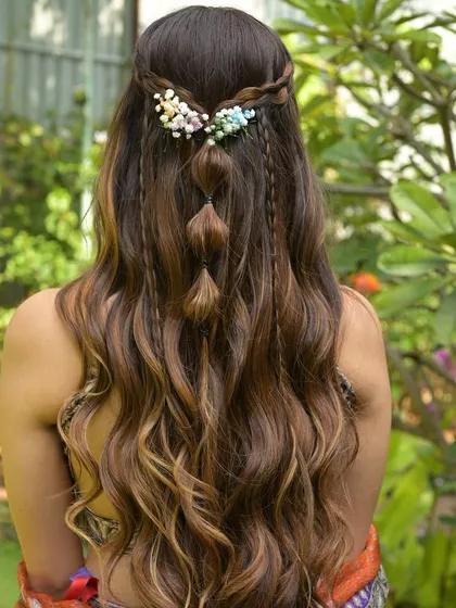 My service is more than just makeup. Here’s a look at the intricate hair artistry my team and I provide, featuring a beautiful bubble braid with delicate floral accessories, perfect for a fun Mehendi or Haldi event.