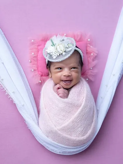 That precious newborn smile. I patiently wait for these fleeting moments. This baby girl, swaddled in a pink sling, gave us the most heartwarming smile, which I was ready to capture.