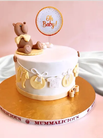 Oh Baby! This sweet teddy bear themed cake is perfect for a baby shower or a first birthday. The neutral colours and adorable details like tiny clothes on a line make it a heartwarming and charming choice.