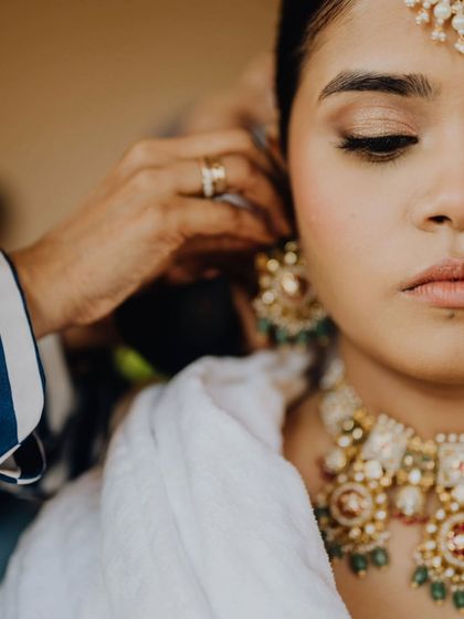 A close-up of the bride getting her earrings put on, a small but significant moment in the getting-ready process.