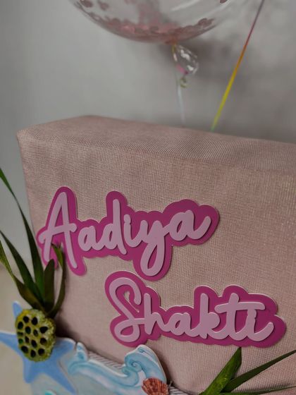 A detailed shot of the personalized 'Aadiya Shakti' name in pink lettering.