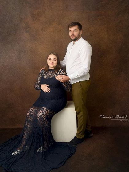 A classic and simple couple's portrait. The focus is entirely on their connection, with the dad-to-be holding his partner's hand supportively.