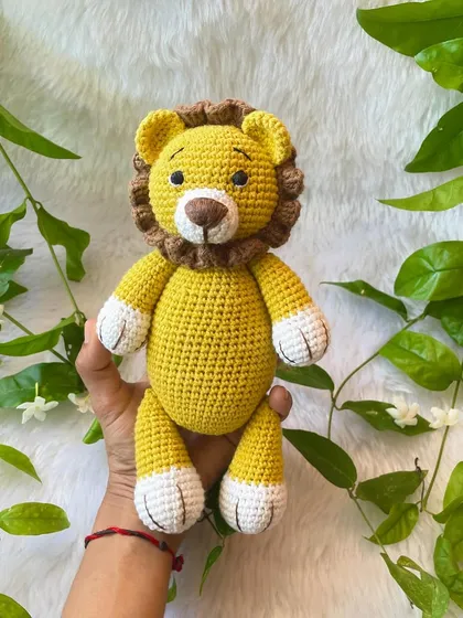 Holding the friendly lion plushie. His mane is made with a different textured yarn to make him look extra fluffy.