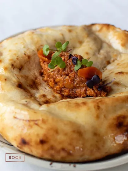 The Smoked Butter Chicken Kulcha, served hot and fresh. It's a perfect choice for a chilly winter evening, offering warmth and comfort in every bite.
