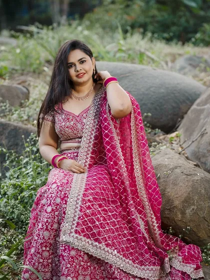 A beautiful outdoor shot of the bride at her ring ceremony, wearing a stunning pink lehenga.