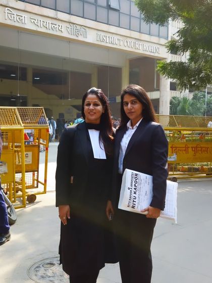 Outside the District Court in Rohini with a junior associate. I am committed to mentoring the next generation of lawyers while serving my clients.