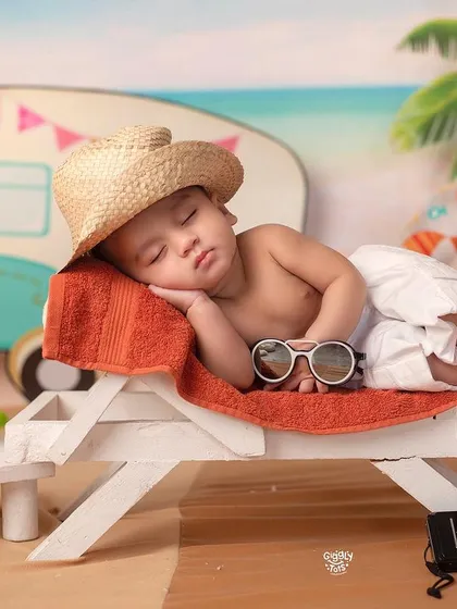 Beating the heat with a good sleep. This baby is enjoying a peaceful nap on a beach lounge chair in our summer-themed studio.