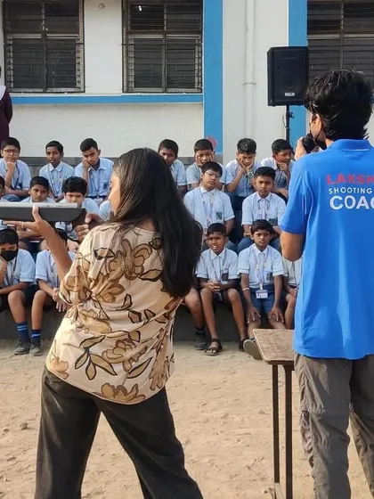 A coach demonstrating the correct shooting stance to students during a free workshop. This hands-on instruction is key to giving them a proper and safe introduction to the sport.