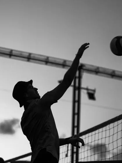 A silhouette of a player serving, the arm extended in a graceful, powerful arc.