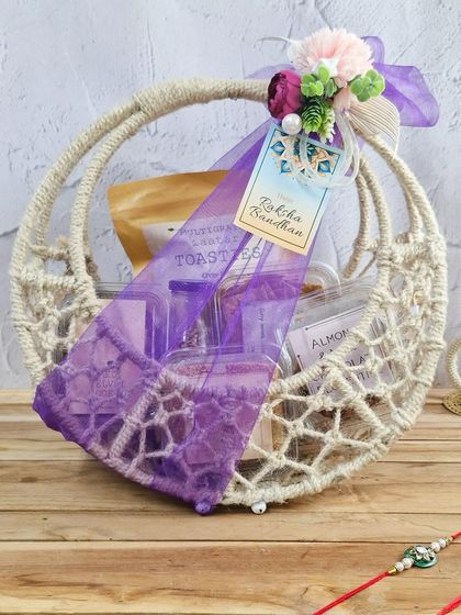 A beautiful macrame basket hamper for Rakhi, filled with our signature snacks and wrapped in festive purple. It's a stylish and heartfelt gift for your sibling.