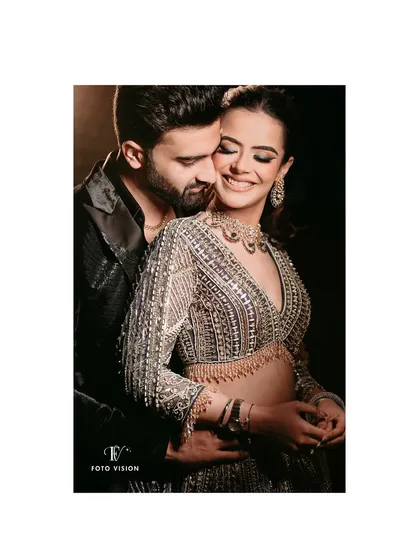 A warm embrace, capturing the love and happiness of the couple. The lighting emphasizes the intricate details of the bride's stunning, embellished gown.