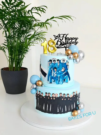 A two-tier cake for a K-Pop fan, celebrating the bands Enhypen and Seventeen. The cake is decorated with edible images of the band members and stylish balloon accents.