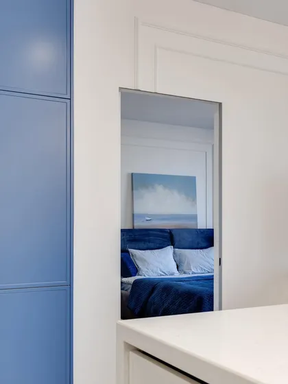 A clever design element where a niche in the wall provides a visual connection between the kitchen and the bedroom.