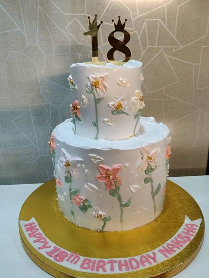 An elegant two-tiered cake for an 18th birthday. The design features a delicate hand-painted floral pattern, making it a sophisticated choice for a coming-of-age celebration.