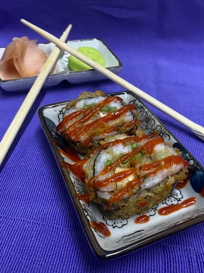 Control your tempura! This crispy tempura sushi roll is drizzled with a sweet and spicy sauce, offering a satisfying crunch with every bite.