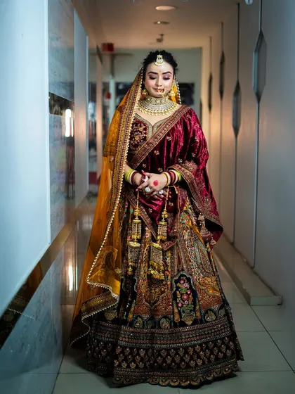 A full-length shot of a bride in a magnificent velvet lehenga. This demonstrates our students' ability to work with rich fabrics and create a look of pure opulence.