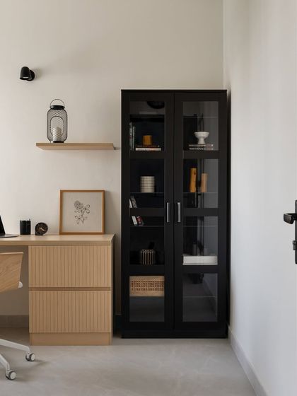A direct view of the Japandi-style home office, showcasing the balance between the black storage cabinet and the light wood desk.