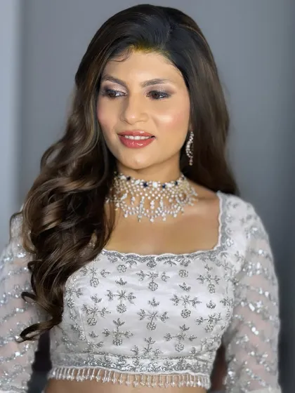 A side profile showing the clean lines of the makeup and the soft, romantic hairstyle.