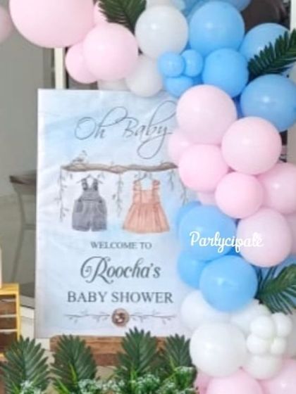 The welcome sign for Roocha's baby shower. The sign is framed by a lovely pink and blue balloon arrangement, creating a sweet and inviting entrance for guests.