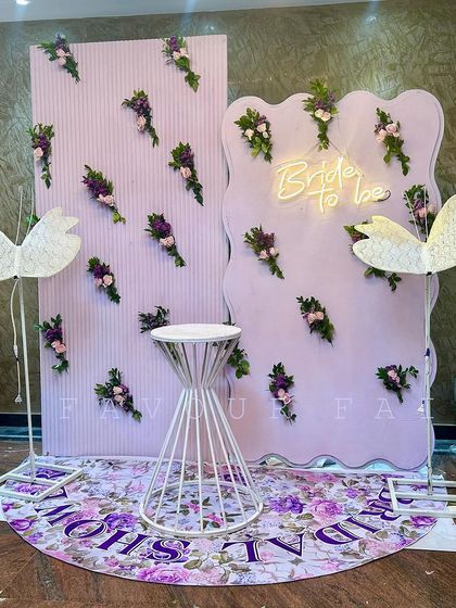 A unique and artistic 'Bride to be' setup with a lavender theme. We used custom-shaped backdrops, a floral wall pattern, and swan props to create a modern and whimsical photo area.