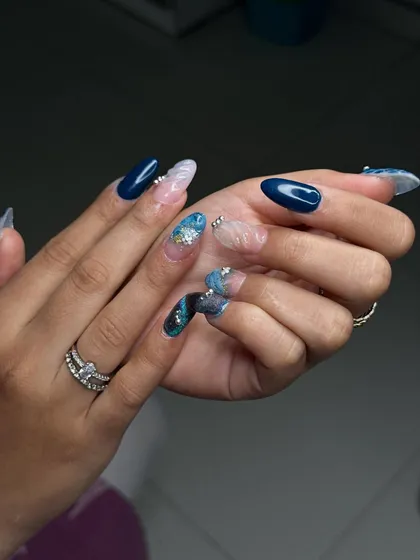 Another angle of this intricate blue nail art set, showing the combination of solid colour, marble effects, and glitter for a dynamic and trendy look.