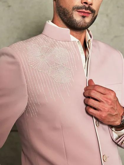 A close-up on the exquisite hand-embroidery. The fine threadwork creates a subtle floral pattern that adds a touch of bespoke artistry to the jacket.
