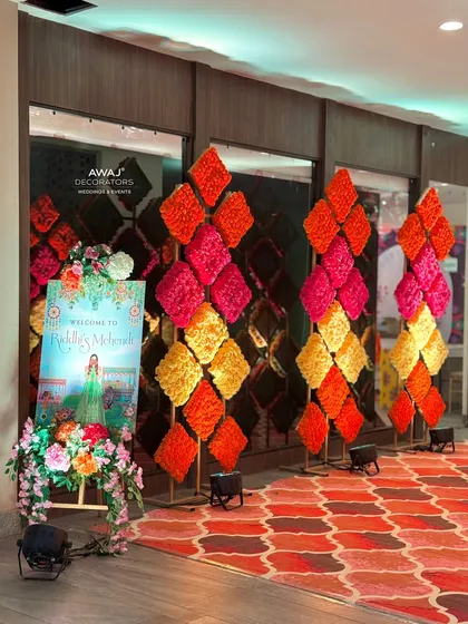 The complete entrance setup for the indoor Mehendi, with a personalized welcome sign and colorful floral decor.