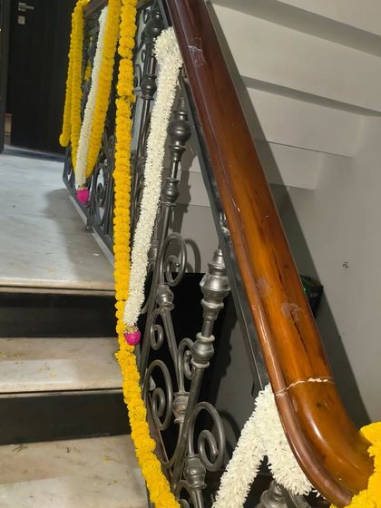 A classic staircase railing decorated with alternating garlands of marigold and jasmine for a traditional festive look.