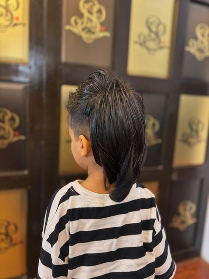 It doesn’t get cooler than this. A back view of a creative kid's haircut, featuring a modern mohawk style that's both fun and stylish.