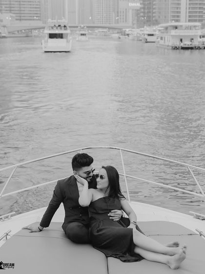 A quiet, romantic moment in black and white on the bow of a yacht. This image focuses on the couple's connection amidst the gentle movement of the water.