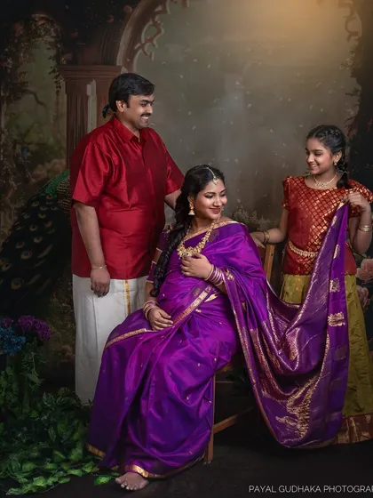 The older daughter joins her parents, holding the pallu of her mother's saree. This pose adds a beautiful dynamic of connection between the generations.