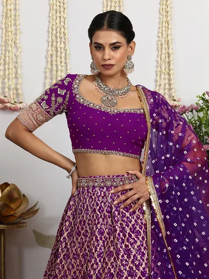 A close-up of the embellished purple blouse, featuring intricate embroidery and a statement silver necklace.
